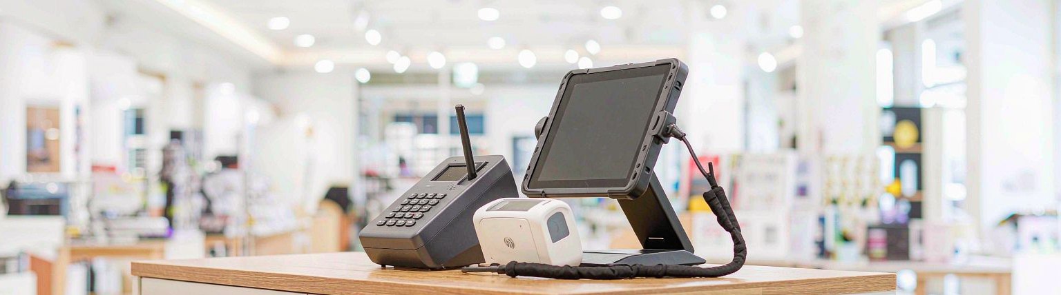 A point-of-sale terminal and card reader on a retail counter